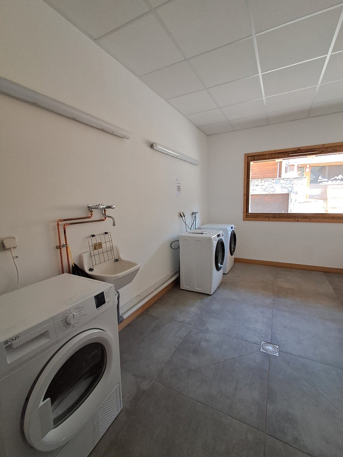Espace lave-linge et sèche-linge au même étage de la résidence.